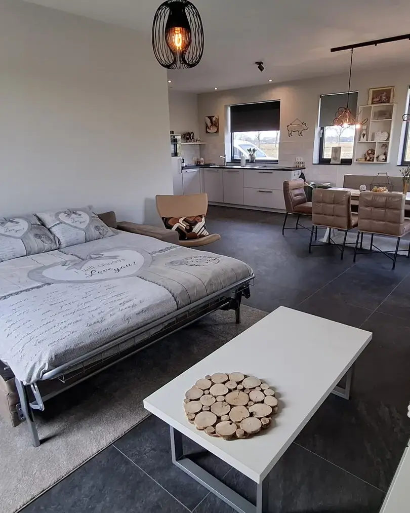 Lichte woonkamer met bank en eethoek